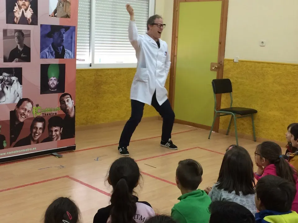 Actor de Chameleon Theatre actuando en inglés ante alumnos sentados en el gimnasio del colegio