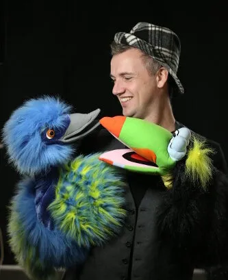 Actor de Chameleon Theatre con dos marionetas de pájaro durante un espectáculo en inglés