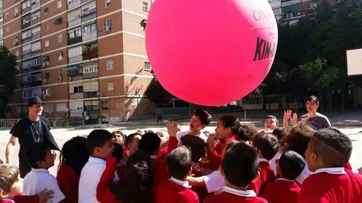 Alumnos de un colegio jugando con una pelota gigante durante una actividad en inglés en el patio